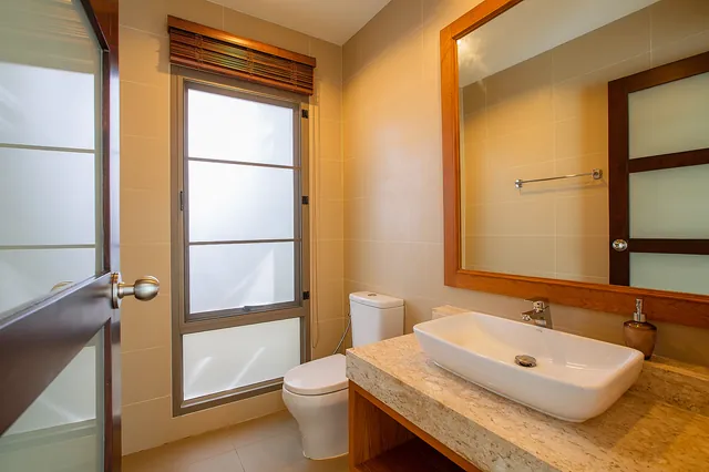 Bathroom with stone countertop and large mirror